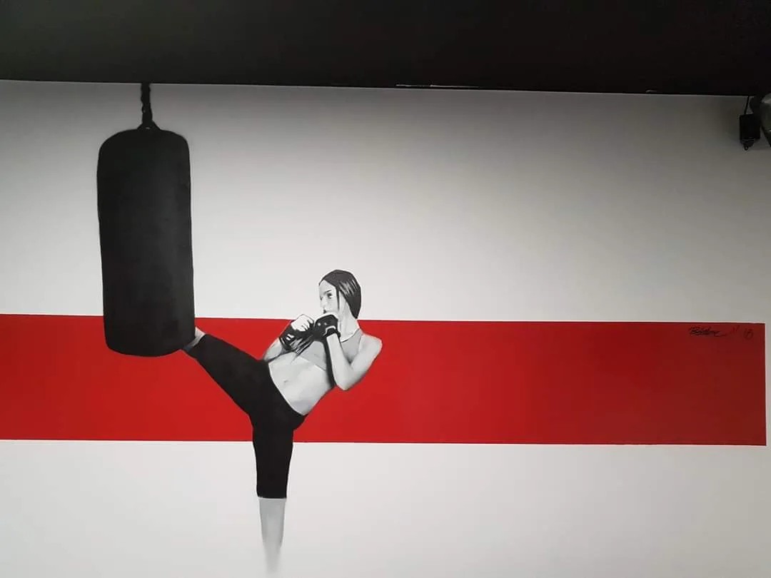 Schwarz-rotes Wandbild einer kickenden Sportlerin