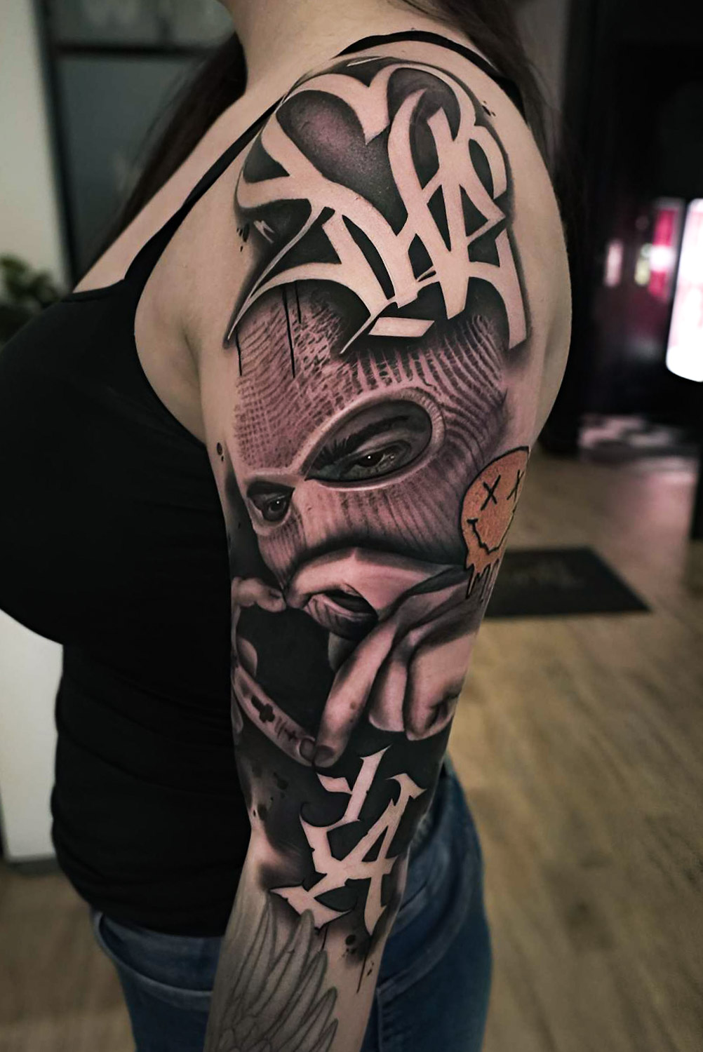 Illustrativer Black-and-Grey-Sleeve mit Graffiti-Elementen und Porträt