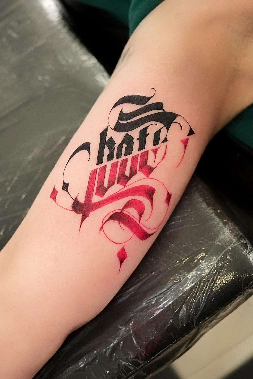 Kalligrafisches Lettering-Tattoo in Schwarz und Rot