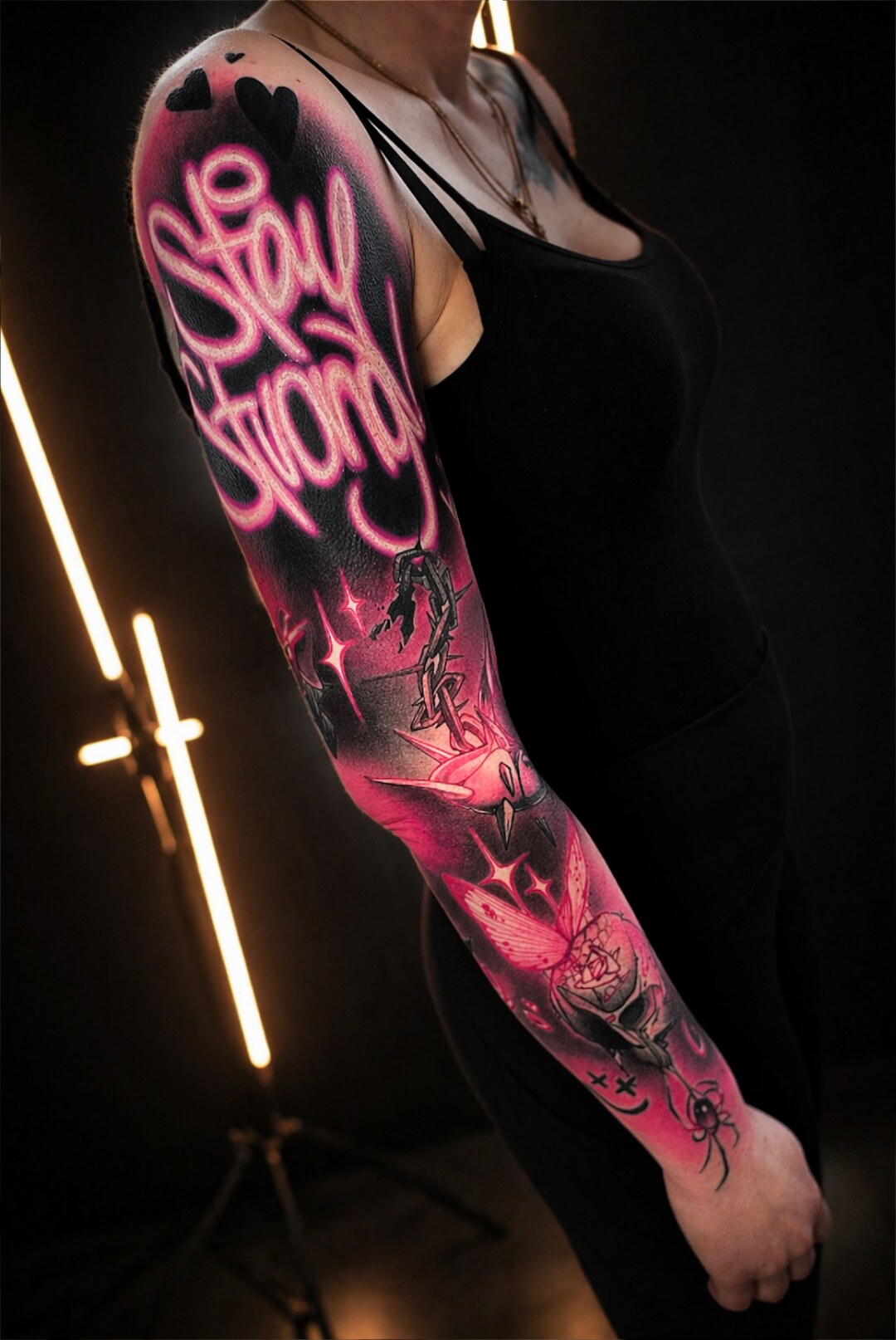 Leuchtend pinkes Graffiti-Tattoo mit dem Schriftzug Stay Strong